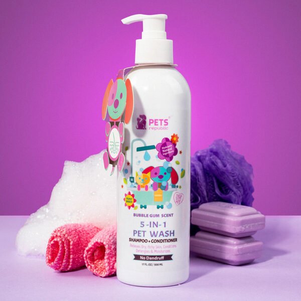 Pets Republic 5-in-1 Shampoo & Conditioner in a white bottle with a pump dispenser, featuring colorful floral and pet graphics, alongside pink sponges and purple soap bars on a purple background.