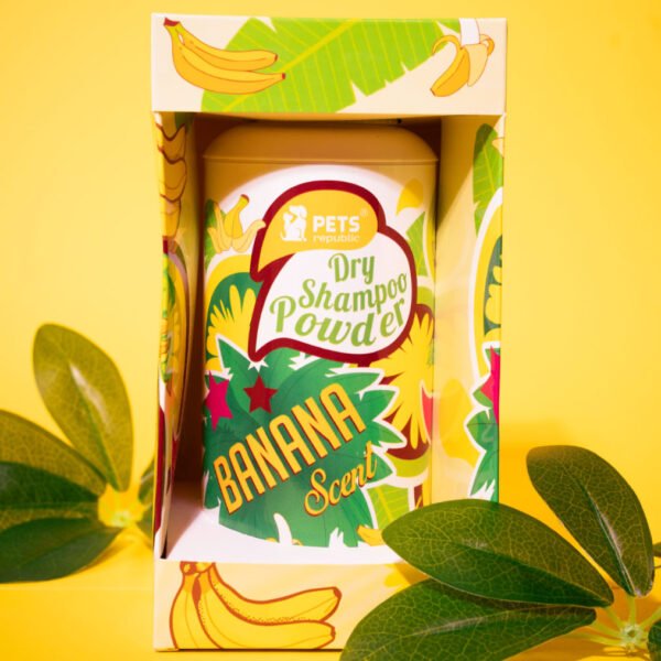 Image of Pets Republic Dry Powder Pet Shampoo in a 500ml container with a vibrant banana design on the packaging, set against a yellow background with green leaves framing the product.