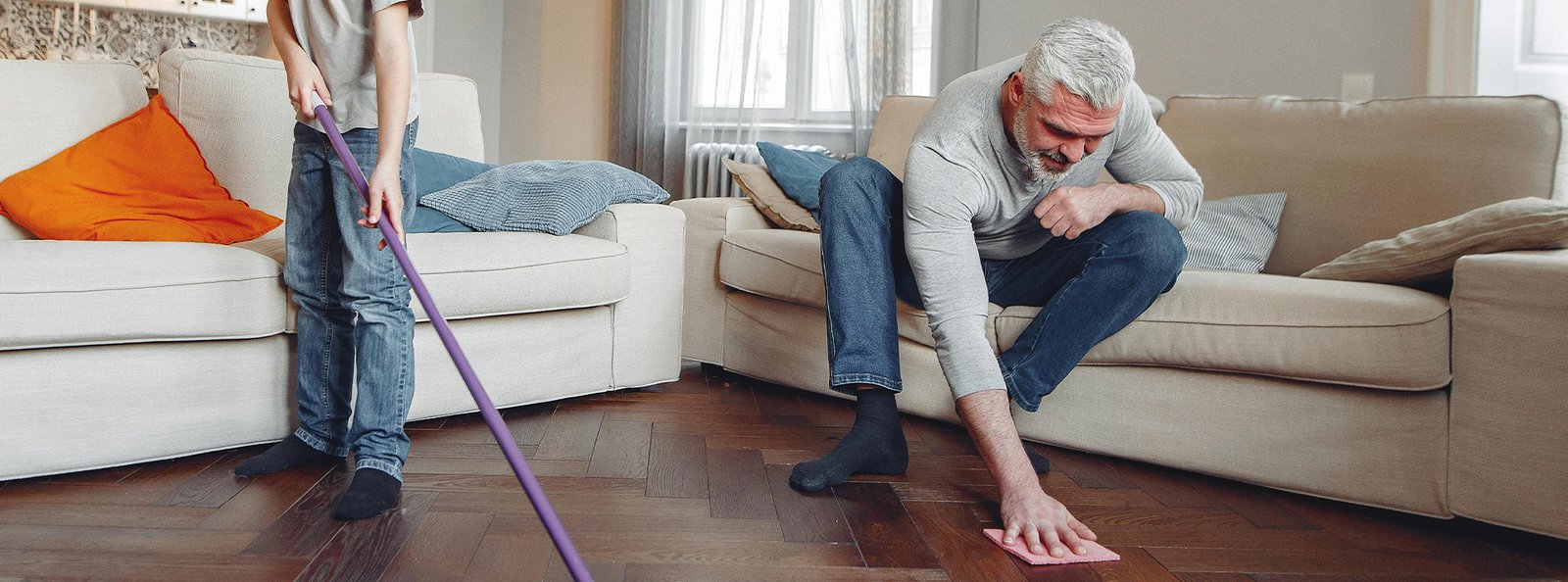 An adult and child cleaning a pee stain on the floor, symbolizing the relief of no longer dealing with stinky accidents using Urine Off Puppy Cleaning Spray