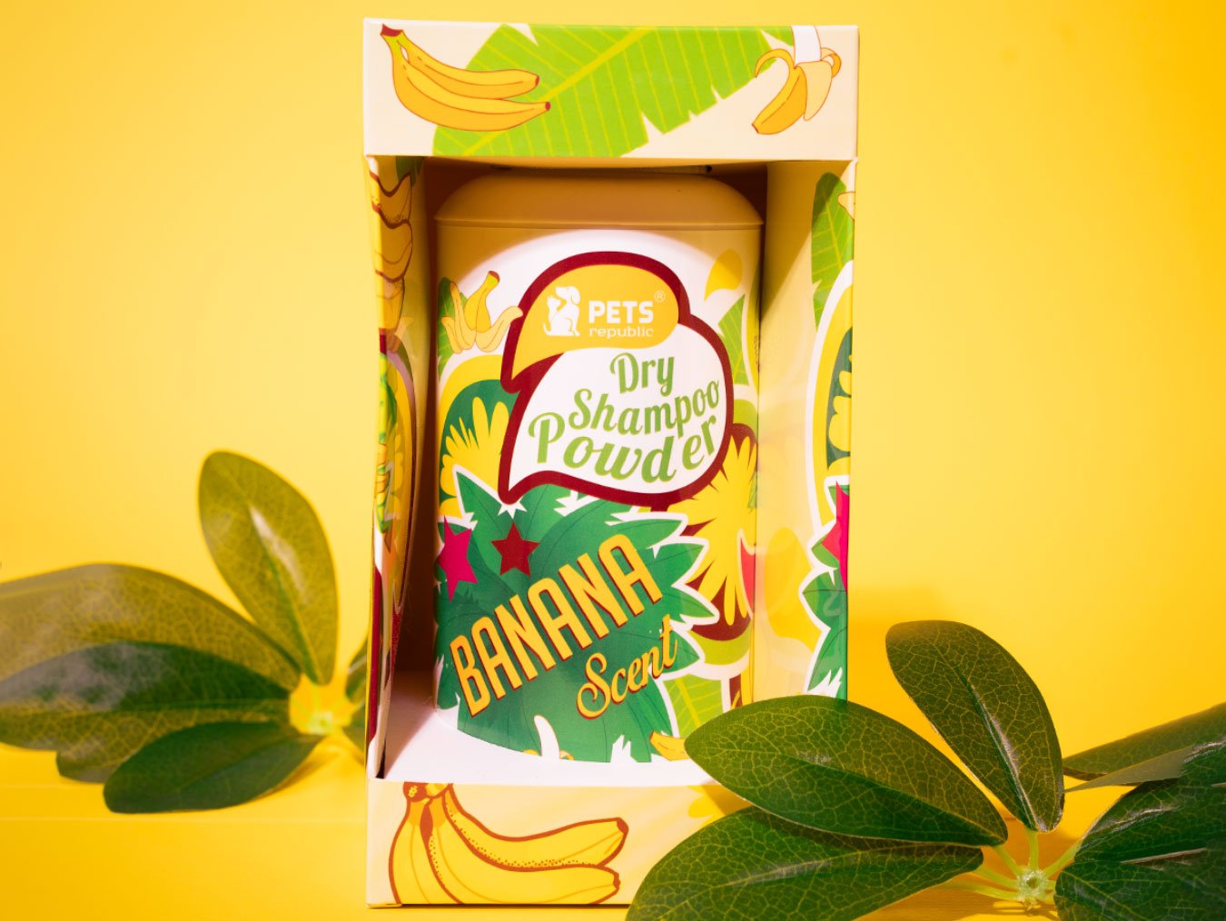 Image of Pets Republic Dry Powder Pet Shampoo in a 500ml container with a vibrant banana design on the packaging, set against a yellow background with green leaves framing the product.