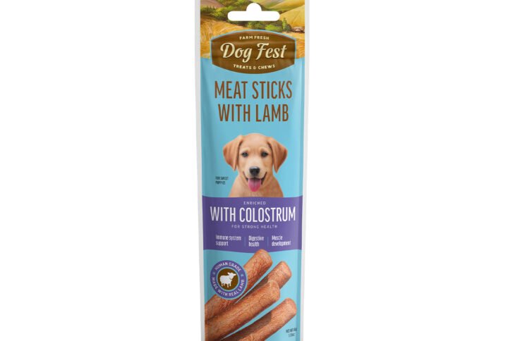 Packaging of Dog Fest Meat Sticks with Lamb for puppies, featuring a blue and white color scheme, an image of a puppy, and a ‘With Colostrum’ badge.