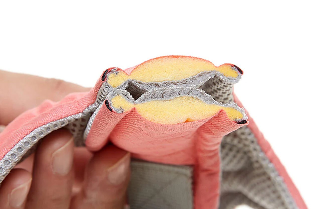 Close-up cross-section of a pink memory foam material, highlighting its layers and structure