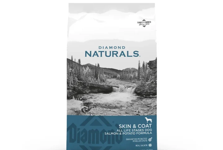 Studio shot of the Diamond Naturals Skin & Coat All Life Stages Dog Salmon & Potato Formula bag. The design features a white top section with a black-and-white waterfall landscape and a teal bottom section with key nutritional claims, including "Real Salmon" and "Omega Fatty Acids for Skin & Coat."