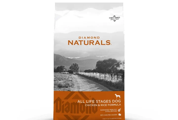 Studio shot of the Diamond Naturals All Life Stages Dog Chicken & Rice Formula bag. The design features a white top section with a black-and-white rural landscape and a warm orange bottom section with key nutritional claims, including "Cage-Free Chicken" and "Guaranteed Probiotics 80 Million CFU/LB."