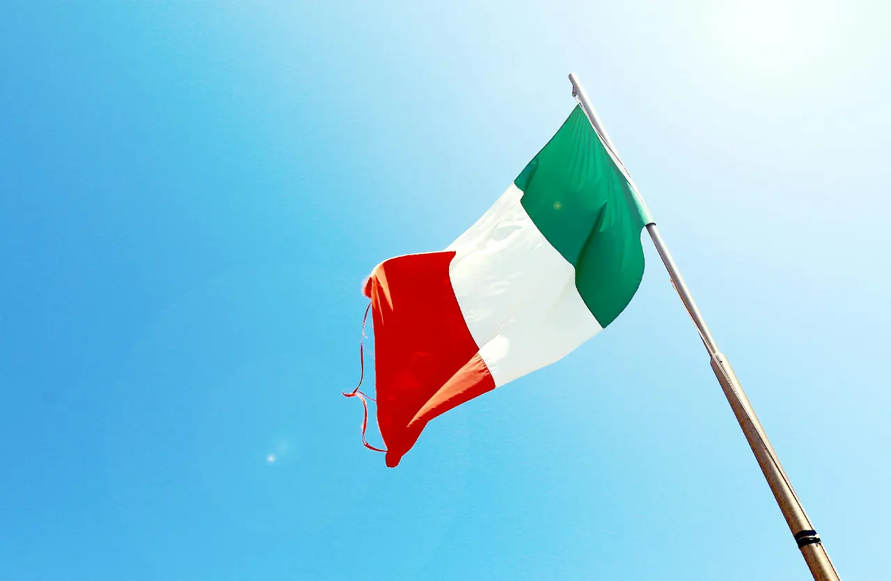 The Italian flag waving against a clear blue sky, visually connecting the product to its "Premium Italian Nutrition" aspect.