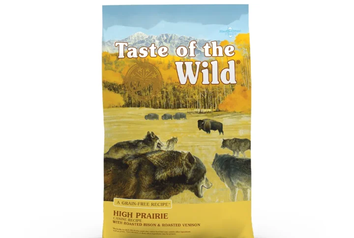 Front view of Taste of the Wild High Prairie Canine Recipe dog food bag showing a scenic illustration of wolves observing grazing bison on a prairie, with bold branding and grain-free callouts.